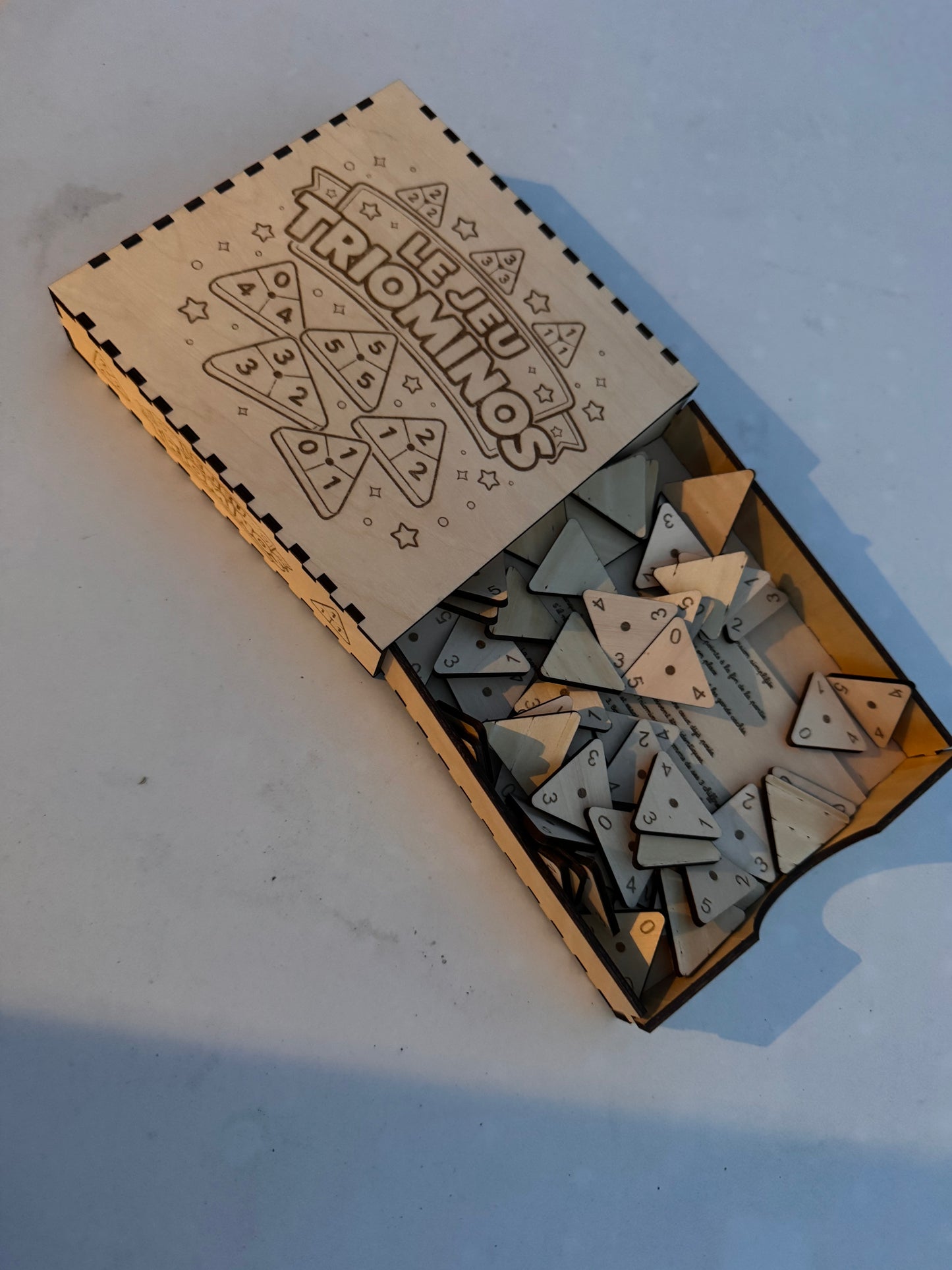 Fourni : La boite de jeu, règle du jeu, pièces triominos